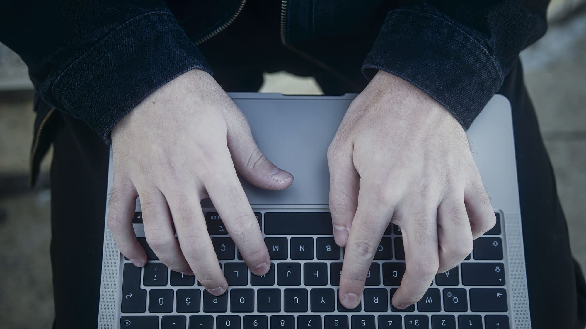 Dłonie na klawiaturze laptopa, widok z góry
