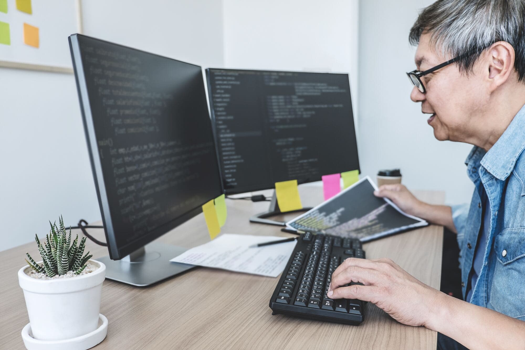 Starszy programista przy monitorach z kodem