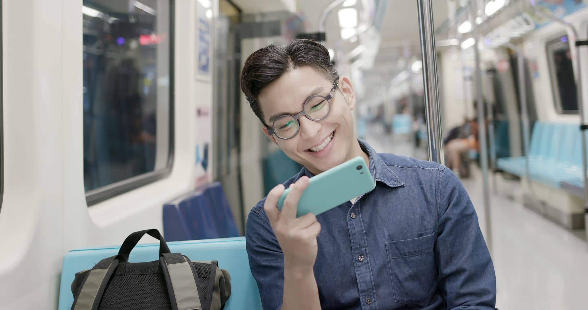 Mężczyzna ogląda film na telefonie w wagonie metra