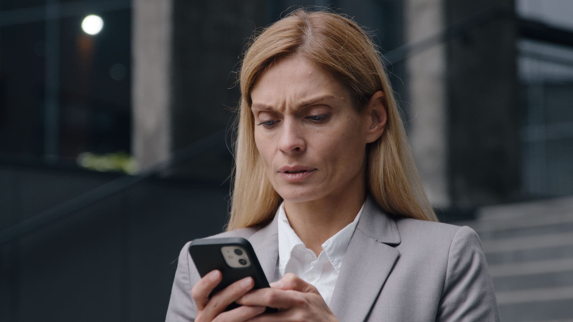 Zaniepokojona kobieta patrzy w telefon